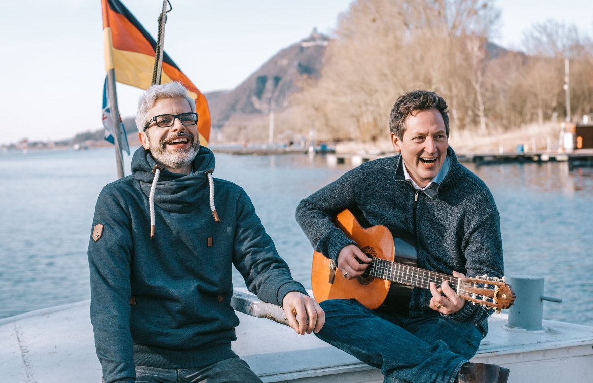 Eckart von Hirschhausen und Tobias Esch auf einem Boot, mit Gitarre